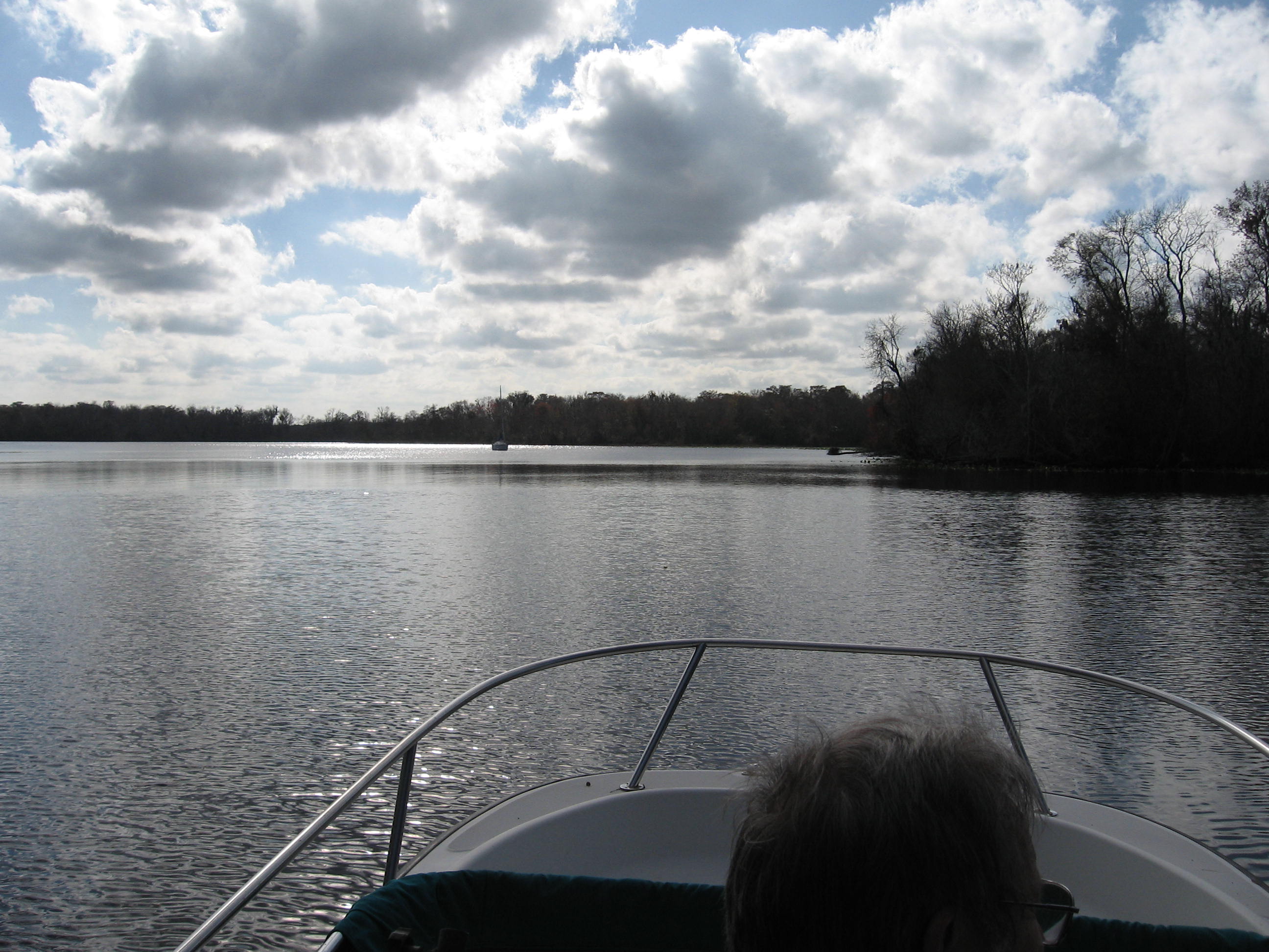 Boat on calm river under cloudy sky